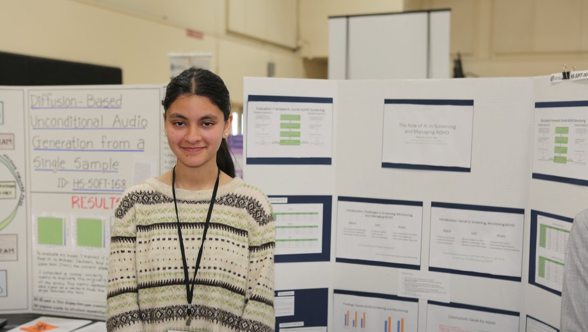 Afrah Nazar standing beside her ADHD project poster at the 2024 science fair